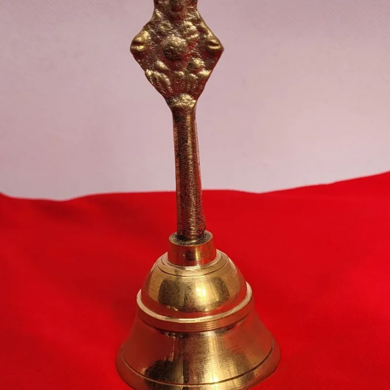 Cast brass puja bell with an ornately moulded handle