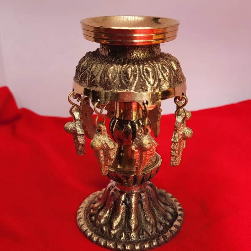Brass oil lamp with a lotus bowl and hanging cast figures