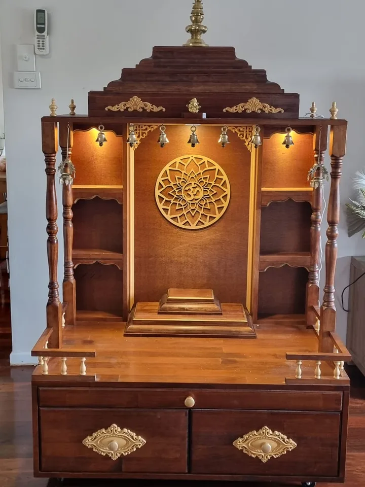 Brown Japan mandir with a carved gold om medallion and a deep drawered base