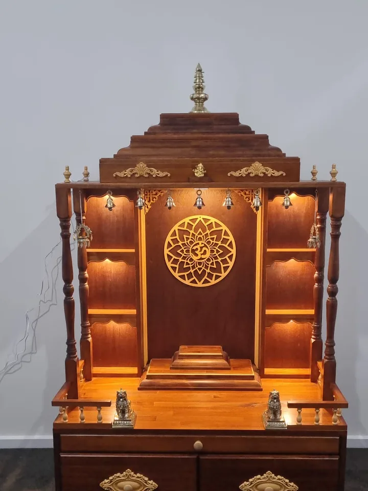 Tall Brown Japan mandir with slender turned columns and a row of brass temple bells