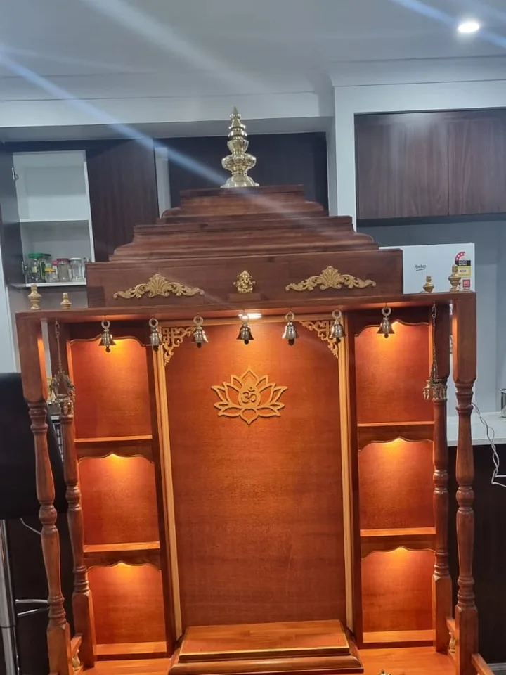 Brown Japan mandir with a lotus om crest, warm interior lighting and a matching timber step