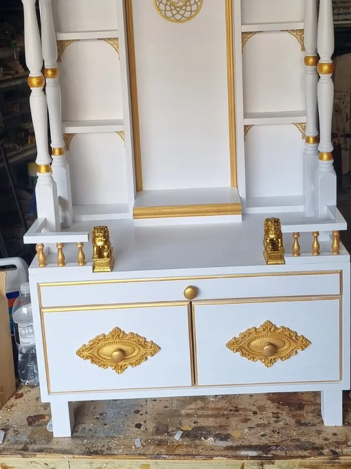 Newly finished ivory and gold mandir in the workshop, with gilded corner brackets and drawer plates