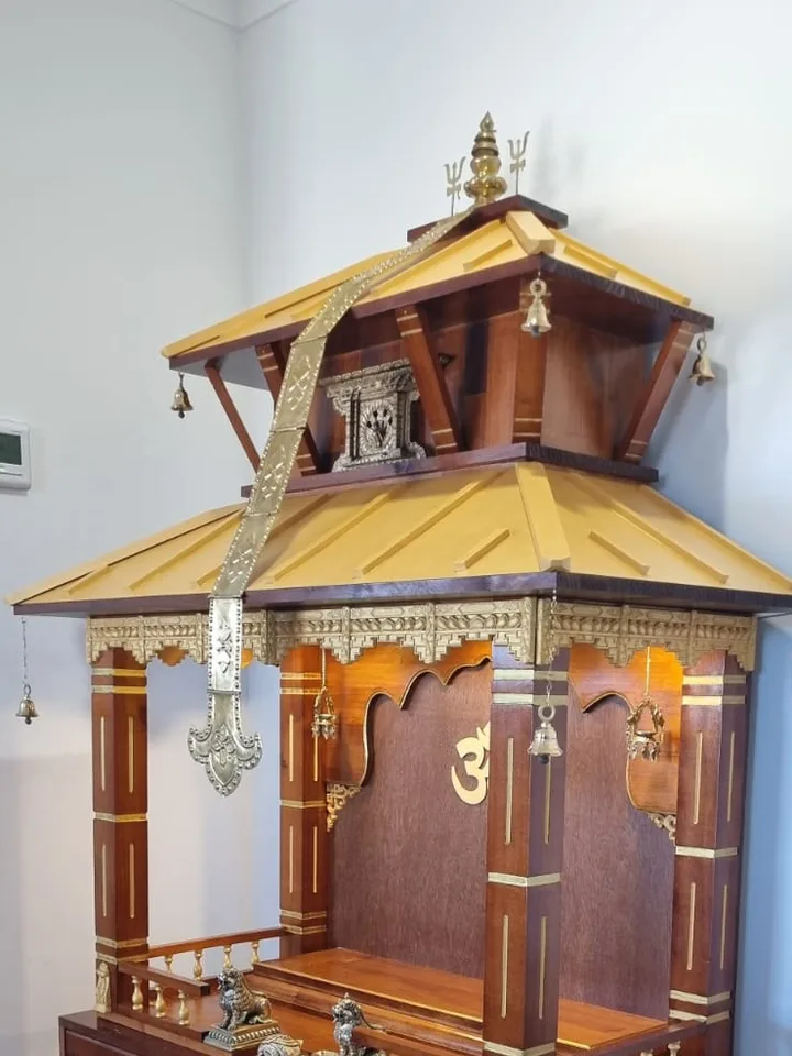 Two-tier teak mandir seen from the side, showing the depth of the canopy and drawered plinth
