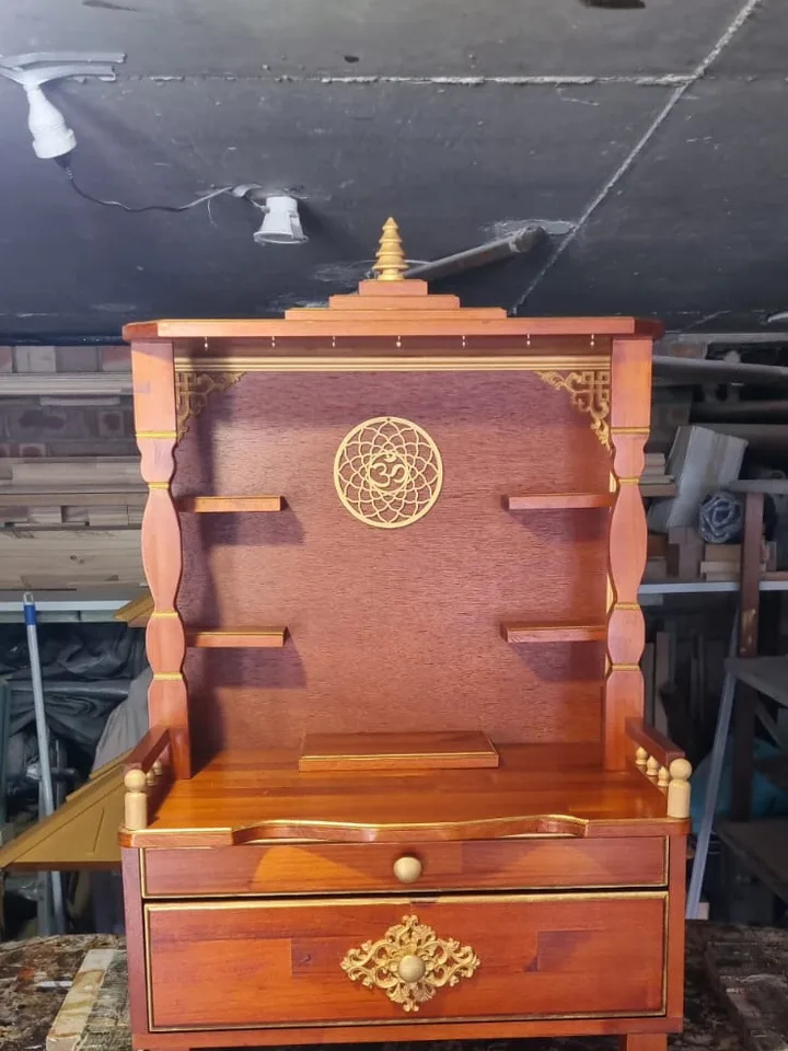 Compact tabletop Brown Japan mandir with a gold om roundel and a single carved drawer